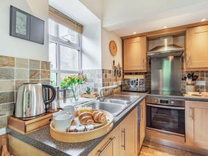 a kitchen with a sink with a tray of bread at 2 bed in Bardon Mill 88032 in Bardon Mill