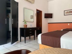 Habitación de hotel con cama y espejo en HOTEL VILLA LAS ROSAS TEPIC, en Tepic