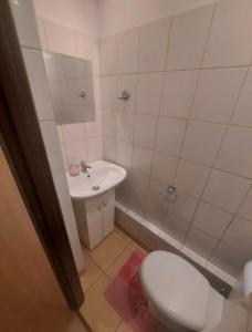 małą łazienkę z toaletą i umywalką w obiekcie Travel House Wrocław we Wrocławiu