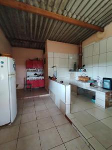 eine große Küche mit weißen Schränken und einem Kühlschrank in der Unterkunft BiaMar in Luminárias