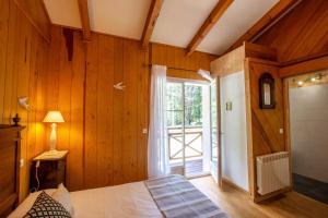 um quarto com paredes de madeira, uma cama e uma janela em BAVELLA VISTA em Zonza