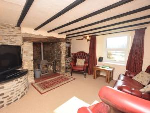 a living room with a couch and a tv and a fireplace at 2 Bed in Clovelly FORDM in Woolfardisworthy