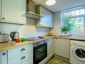 uma cozinha com armários brancos e uma máquina de lavar louça em 2 Bed in Llangynidr BN052 em Llangynidr