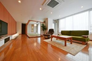 a living room with a green couch and a table at Pleasure Maruyama - Vacation STAY 52798v in Sapporo