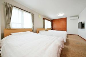 2 Betten in einem Zimmer mit weißer Bettwäsche in der Unterkunft Pleasure Maruyama - Vacation STAY 52798v in Sapporo