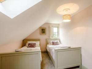 2 bedden in een zolderslaapkamer met een raam bij 3 bed in Ilminster 77987 in Cudworth