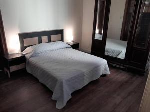 1 dormitorio con cama y espejo grande en Apartamento de estilo en edificio patrimonial en Montevideo