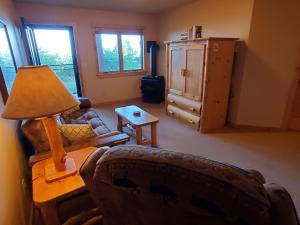 ein Wohnzimmer mit einem Sofa und einem Tisch mit einer Lampe in der Unterkunft Incredible Views w Garage on Lake and bike trail in Tofte