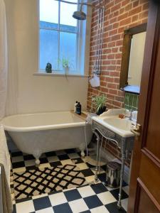 a bathroom with a bath tub and a sink at Lovely room in period townhouse in Winchester