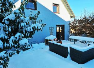a yard covered in snow with a table and bench at Ferienhaus am Nationalpark Eifel in Dreiborn