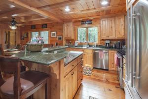 uma grande cozinha com armários de madeira e um frigorífico em Exquisite Log Cabin in the Pines and Very Private em Sonora