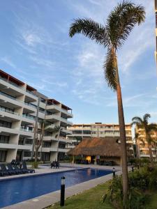 a palm tree in front of a large building at Nuevo Vallarta Lovely 2 bedroom condo pool front in Nuevo Vallarta 