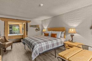 una camera da letto con un letto, una sedia e un tavolo di Stonegate Lodge King Bed Fast WiFi 40in TV Salt Water Pool Room #309 a Eureka Springs Altre 13 foto