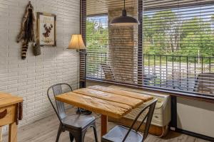 uma sala de jantar com uma mesa e cadeiras e uma janela em Stonegate Lodge King Bed Fast WiFi 40in TV Salt Water Pool Room #309 em Eureka Springs