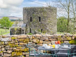 a stone wall with tables and chairs in front of a castle at 2 bed property in Nantyglo 82707 in Nantyglo