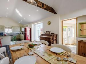 cocina y comedor con mesa de madera y sillas en 3 Bed in Wroxham 79211, en Dilham