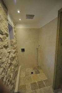 baño con pared de piedra y suelo de baldosa. en Erlebnishof Bauernhof Ferienhaus 