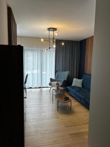 a living room with a blue couch and a table at Apartament Centrum Park 654 in Szklarska Poręba