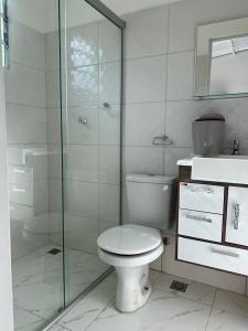 a bathroom with a toilet and a glass shower at Pousada Encanto das águas in Águas de São Pedro
