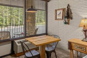 a room with a table and chairs and a balcony at Stonegate Lodge King Bed, WiFi, 50in TV, Fire Pit, Salt Water Pool Room # 310 in Eureka Springs