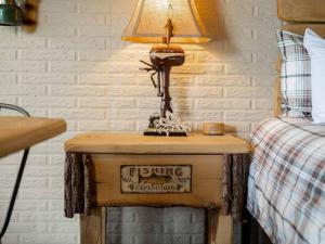 a lamp on a table next to a bed at Stonegate Lodge King Bed, WiFi, 50in TV, Fire Pit, Salt Water Pool Room # 310 in Eureka Springs +14 photos