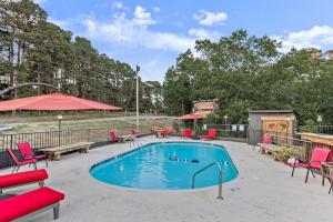 uma piscina com cadeiras vermelhas e uma mesa em Stonegate Lodge King Bed, WiFi, 50in TV, Fire Pit, Salt Water Pool Room # 310 em Eureka Springs