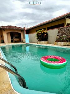 a swimming pool with a red and green object in the water at Pousada Casa Chico in Navegantes