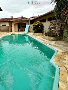 a swimming pool in front of a house at Pousada Casa Chico in Navegantes