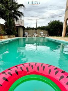 uma piscina com um objecto rosa e verde em Pousada Casa Chico em Navegantes