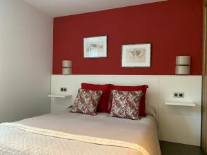 een slaapkamer met rode muren en een bed met 2 kussens bij Tresanea Apartamentos in Ituren