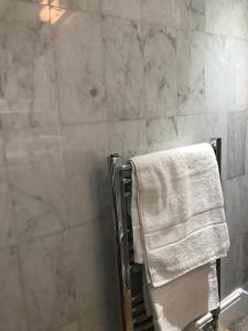 a bathroom with a shower and a towel on a towel rack at Knightsbridge House Apartment in London