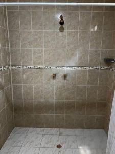 a bathroom with a shower with a tiled floor at Casa finca Santiago Tolú 