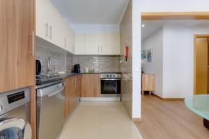 - une cuisine avec des appareils blancs et des armoires en bois dans l'établissement Veiga´s House, à Lagos