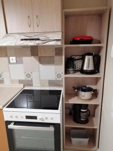 a kitchen with a stove and some shelves at ANIA'S APARTMENT ( ΣΤΟ ΚΕΝΤΡΟ ΤΗΣ ΚΟΖΑΝΗΣ ) in Kozani