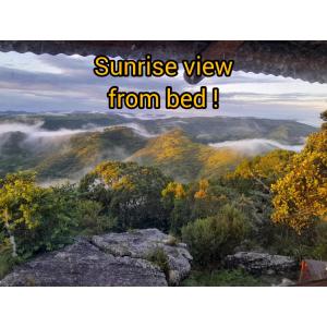 una vista de una montaña nebulosa con las palabras vistas al amanecer desde la cama en Louis at Magwa Falls, en Lusikisiki