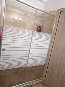 La salle de bains est pourvue d'une douche avec des stores blancs. dans l'établissement ANIA'S APARTMENT ( ΣΤΟ ΚΕΝΤΡΟ ΤΗΣ ΚΟΖΑΝΗΣ ), à Kozani