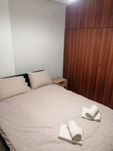 a bedroom with a bed with two towels on it at ANIA'S APARTMENT ( ΣΤΟ ΚΕΝΤΡΟ ΤΗΣ ΚΟΖΑΝΗΣ ) in Kozani