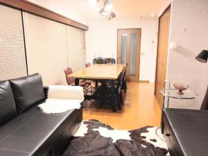 sala de estar con sofá y mesa de madera en Ito Building 1st floor B, 2nd floor, 3rd floor - Vacation STAY 50412v, en Tokio