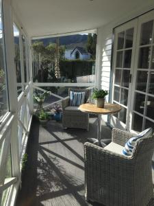 eine Terrasse mit einem Tisch und Stühlen auf einer Veranda in der Unterkunft Te Moana Bed & Breakfast in Waikanae