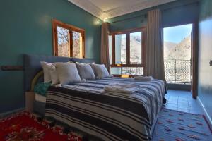 a bedroom with a bed with a large window at La Perle de Neige in Imlil