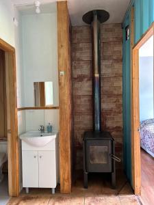 baño con estufa de leña y fregadero en QUELEN PATAGONIA en Villa Cerro Castillo