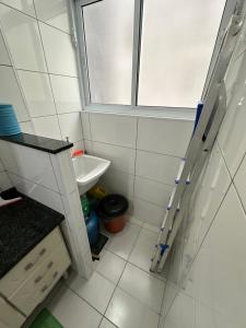 a small bathroom with a sink and a window at Kitnet em frente a praia de Santos in Santos