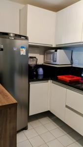uma cozinha com um frigorífico e um micro-ondas em Apartamento mobiliado - Salvador em Salvador