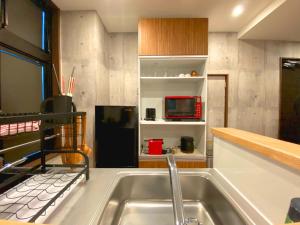 Mongawa的住宿－Sakuraya Ryokan - Vacation STAY 51095v，厨房配有水槽和黑冰箱。