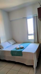 um quarto com uma cama com duas almofadas e uma janela em Apartamento mobiliado - Salvador em Salvador