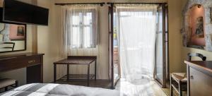 a bedroom with a bed and a desk and a window at Porto Kale Guesthouse in Porto Kagio