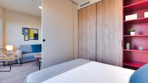 sypialnia z łóżkiem i kanapą w obiekcie Livensa Living Studios Madrid Alcobendas w mieście Alcobendas