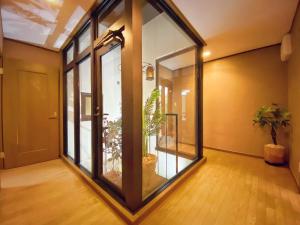 an empty hallway with glass doors and potted plants at Sakuraya Ryokan - Vacation STAY 51711v in Mongawa