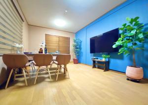 a dining room with a table and a blue wall at Sakuraya Ryokan - Vacation STAY 51711v in Mongawa