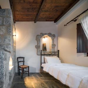 a bedroom with a bed and a chair at Porto Kale in P&oacute;rto K&aacute;yio